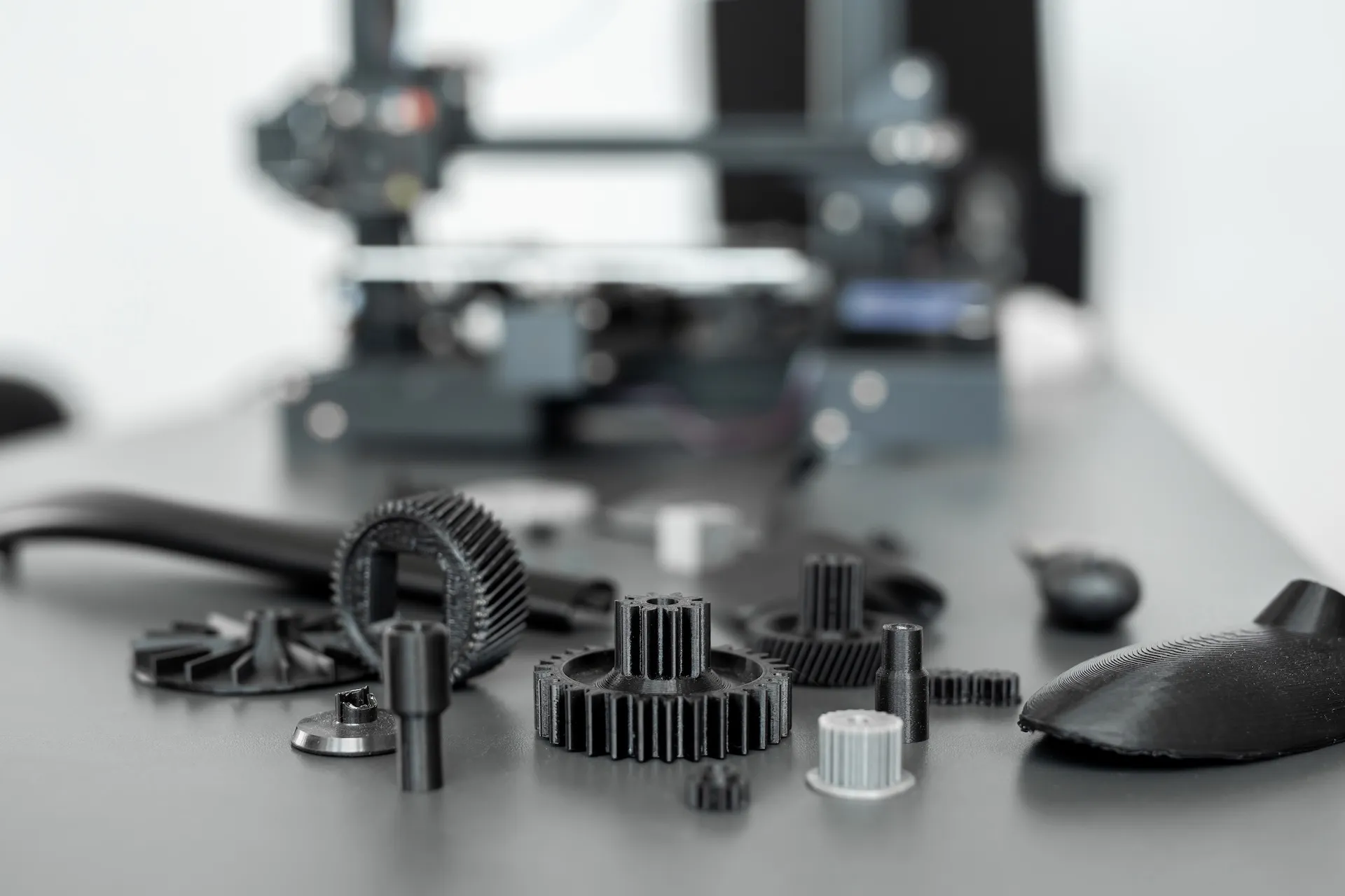 some 3d printed gears and other objects on a table with a 3d printer.